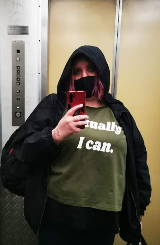 Cheryl Kahla taking a mirror selfie in a hoodie